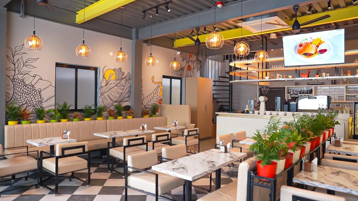 Inside Café du L'Amour: checkerboard floor, marble tables and caged brass pendant lights